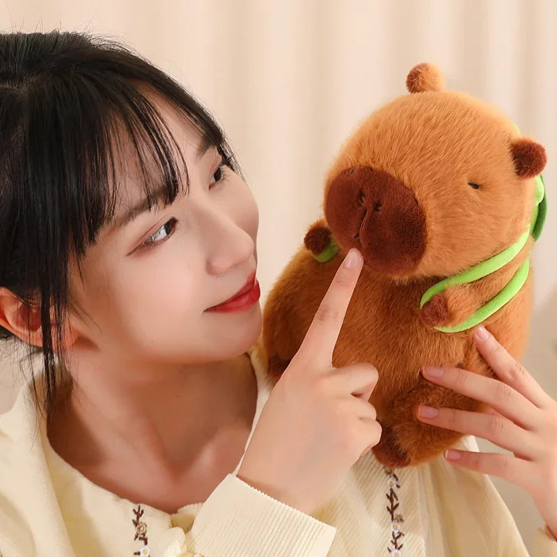 Person holding a kawaii plush toy resembling a brown animal with a green leaf