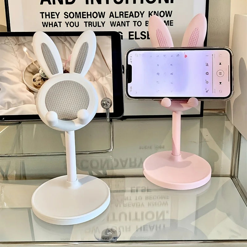 Two kawaii phone stands with bunny ears on a glass surface.