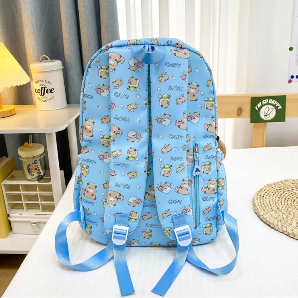 Blue backpack with Kawaii cartoon patterns on a bed