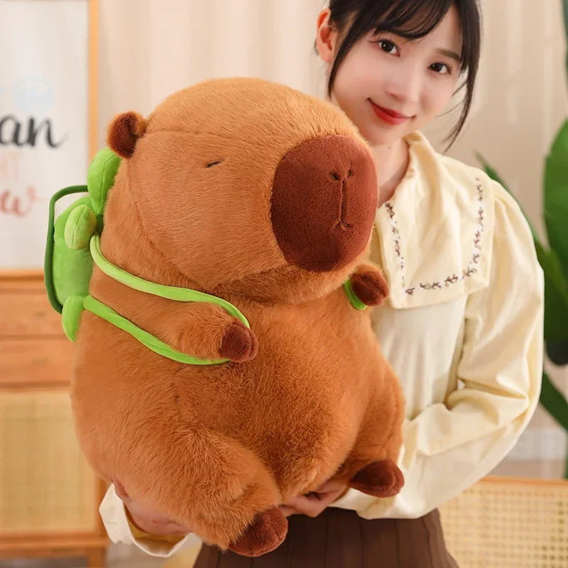 Person holding a large brown kawaii plush bear with green accents