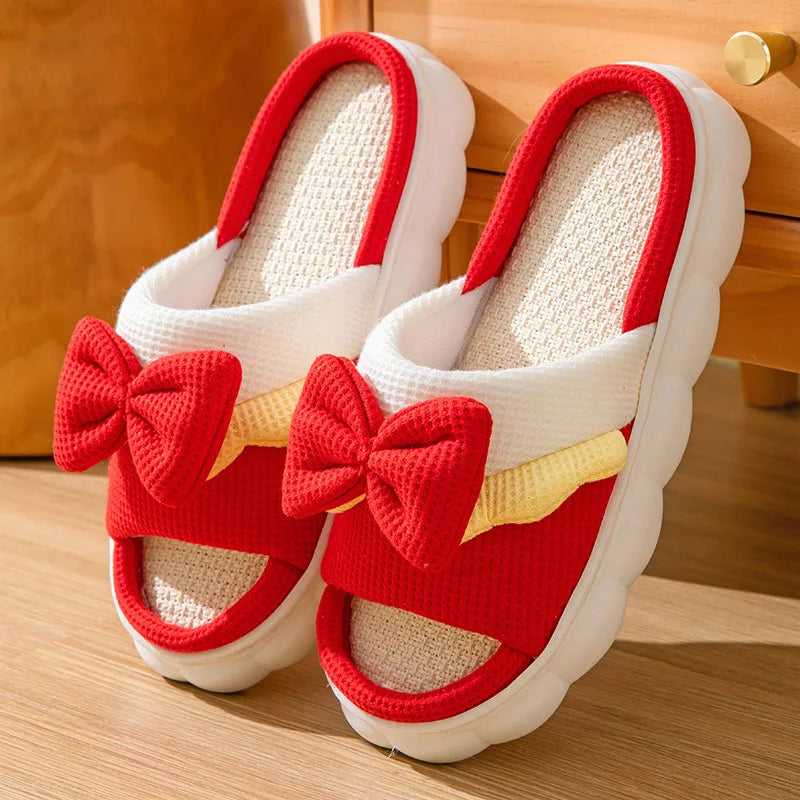 Red and white kawaii slippers with bow details on a wooden floor