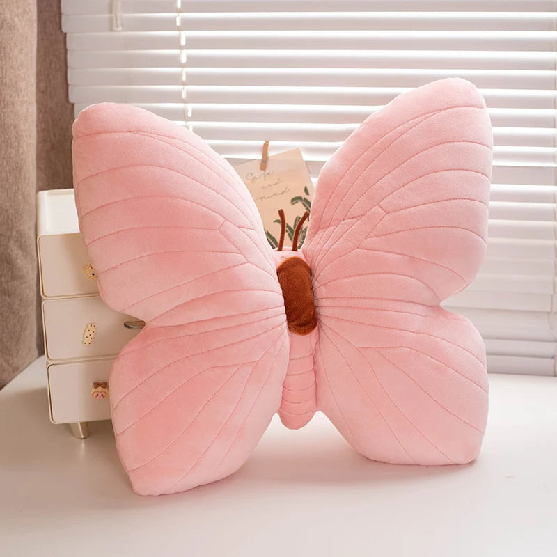 Pink butterfly-shaped kawaii pillow on a bed with a blurred background