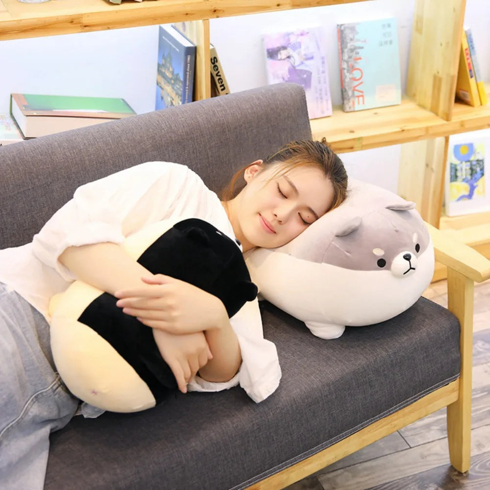 Person lying on a couch with a large plush kawaii animal pillow
