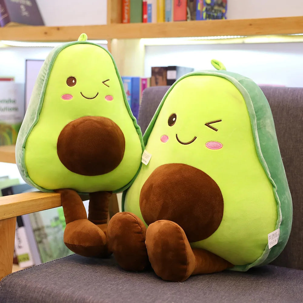 Two plush avocado kawaii toys on a chair with a bookshelf in the background