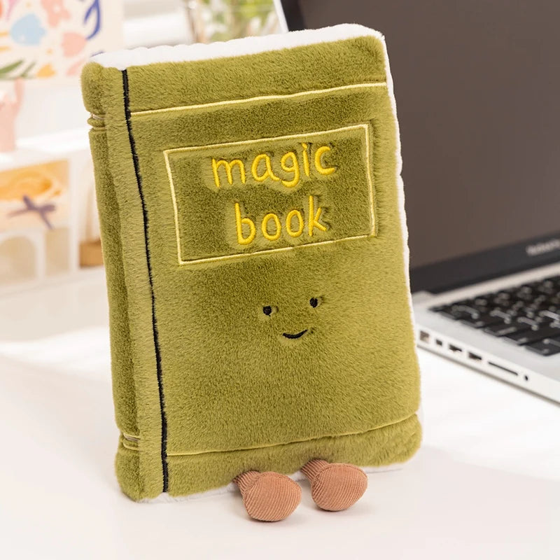 Green kawaii plush toy book with 'magic book' text on a desk