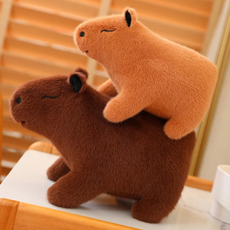 Two brown kawaii plush capybaras on a wooden surface with a blurred background