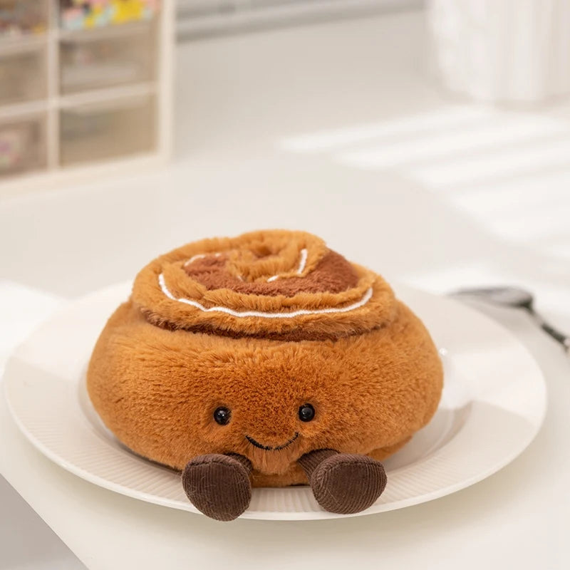 Plush kawaii toy shaped like a cinnamon roll on a white plate