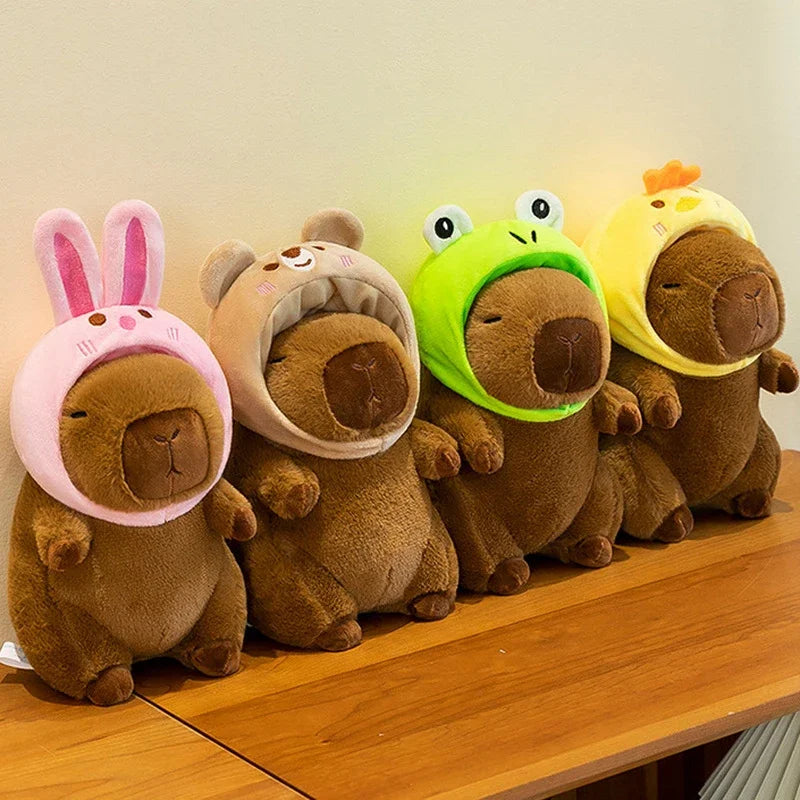 Four brown kawaii plush toys with animal-themed hats on a wooden surface.