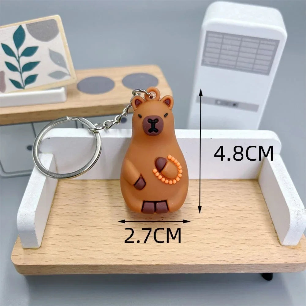 Bear-shaped kawaii keychain with measurements on a wooden stand