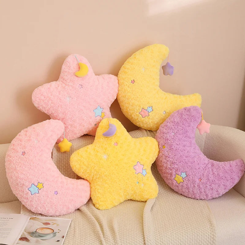 Set of colorful moon, star, and cloud-shaped kawaii cushions on a beige surface.