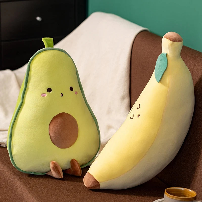 Kawaii plush avocado and banana toys on a couch with a green wall background.