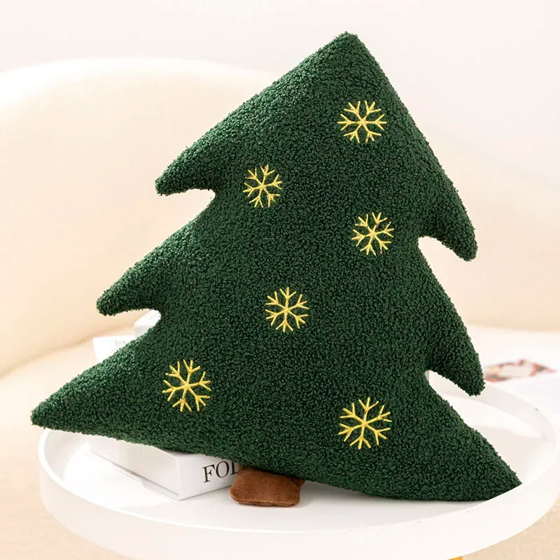 Green tree-shaped kawaii pillow with snowflake patterns on a white surface
