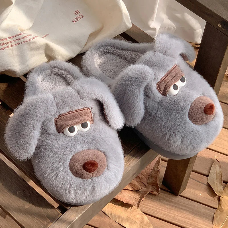 Pair of gray dog-shaped kawaii slippers on a wooden surface