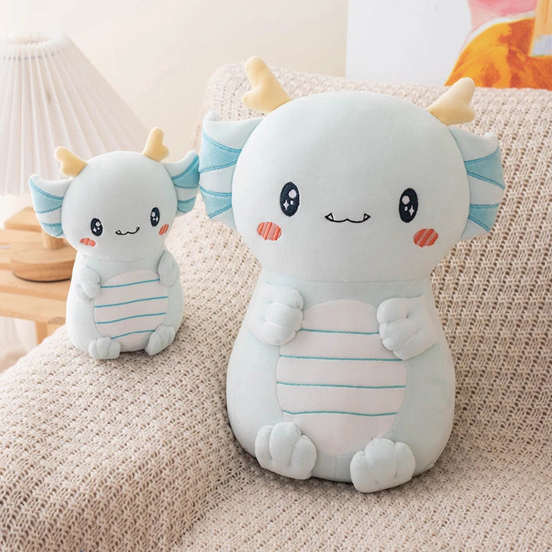 Two cute kawaii plush toys resembling a dragon on a textured surface.