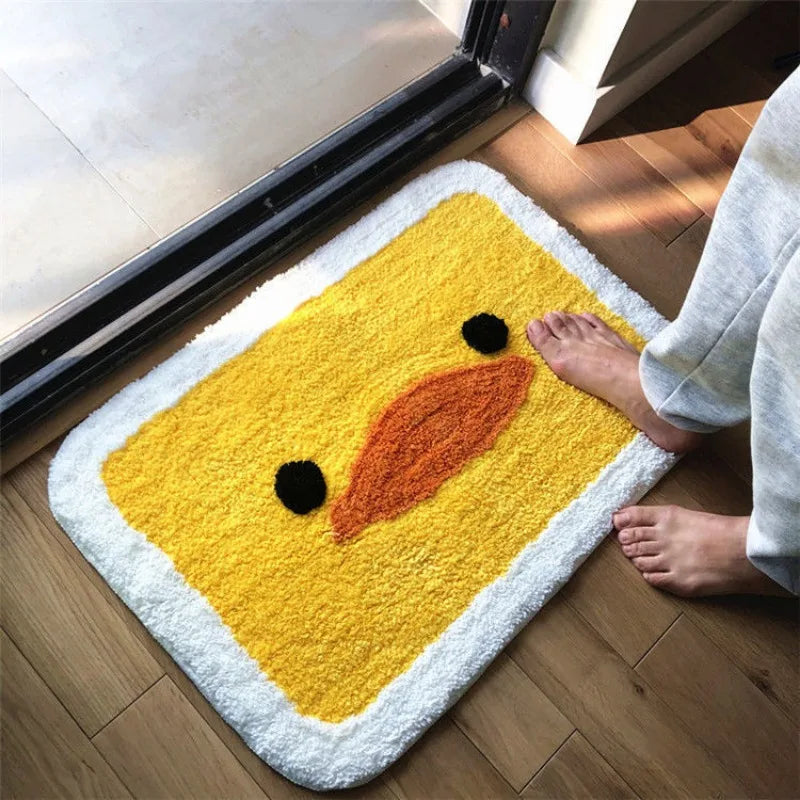 Yellow Kawaii duck-shaped rug on a wooden floor with a person stepping onto it.