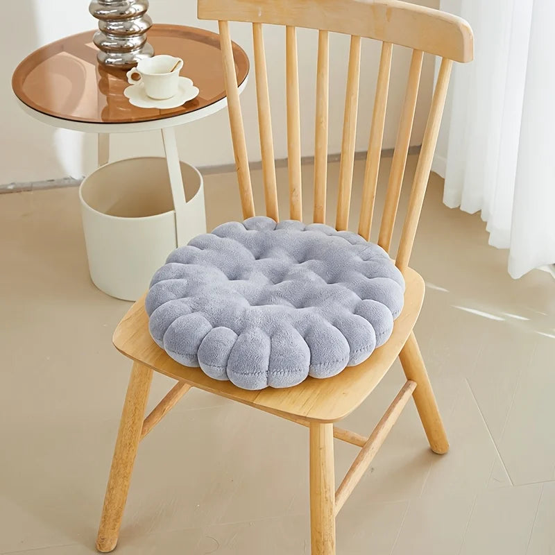 Gray kawaii cushion on a wooden chair with a blurred background