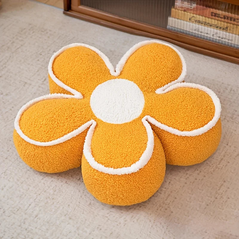 Flower-shaped kawaii cushion with yellow petals and white center on a beige carpet