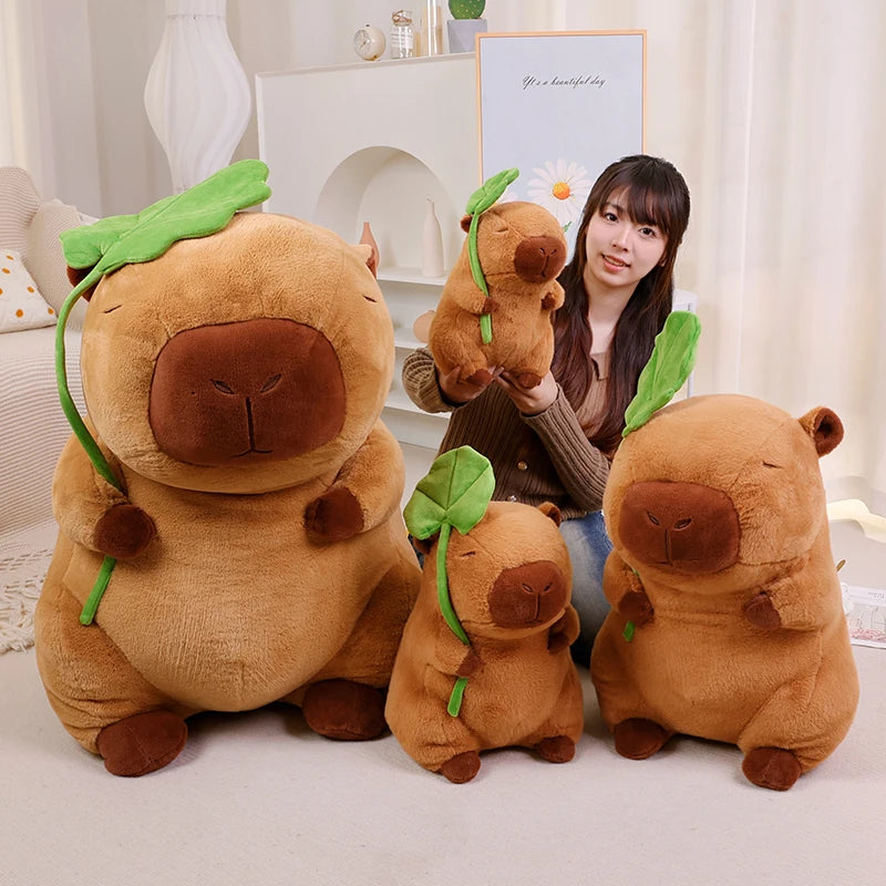 Person holding a kawaii plush toy with four similar plush toys in front on a light-colored surface.