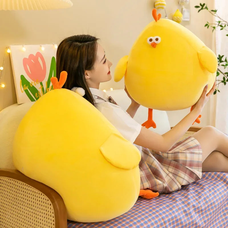 Person holding a large yellow kawaii plush toy in a cozy room.