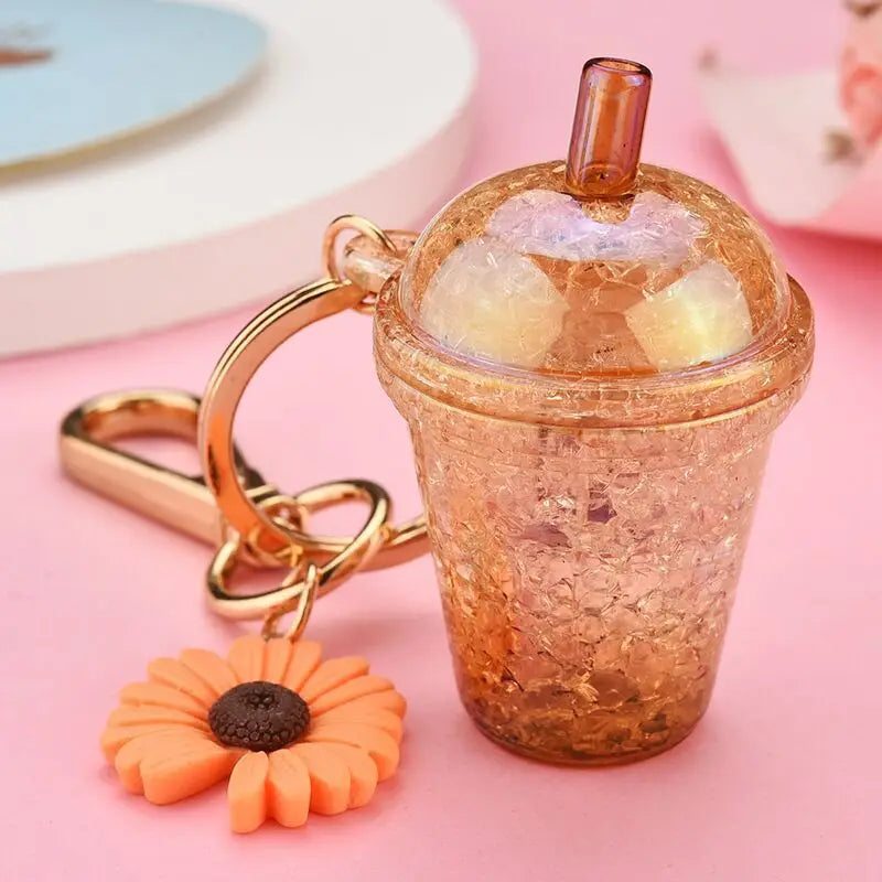 Keychain shaped like a transparent kawaii cup with a straw on a pink background