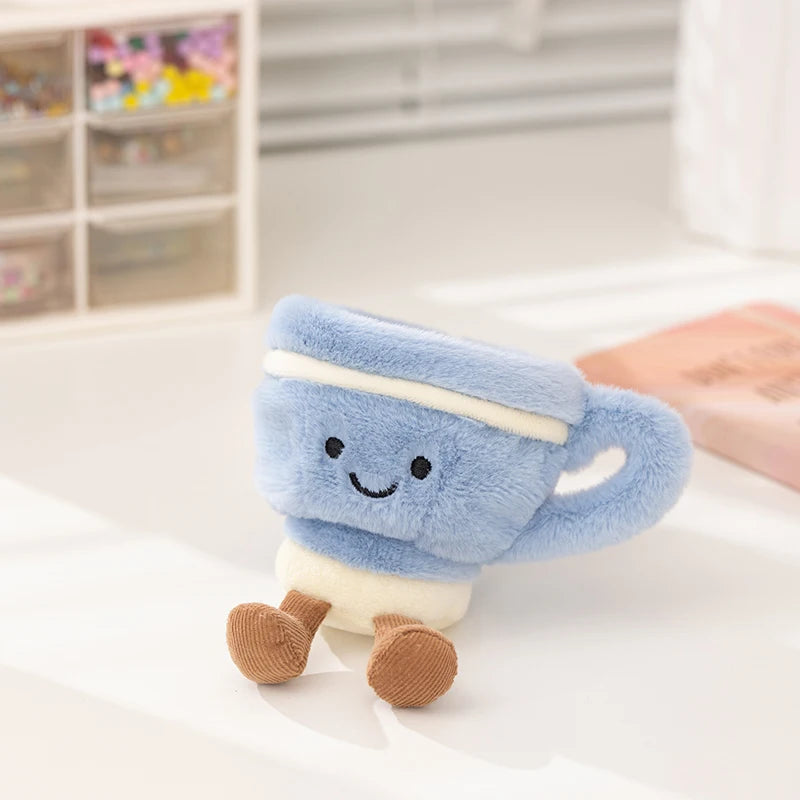 Plush kawaii toy resembling a blue cup with a smiling face on a white surface.