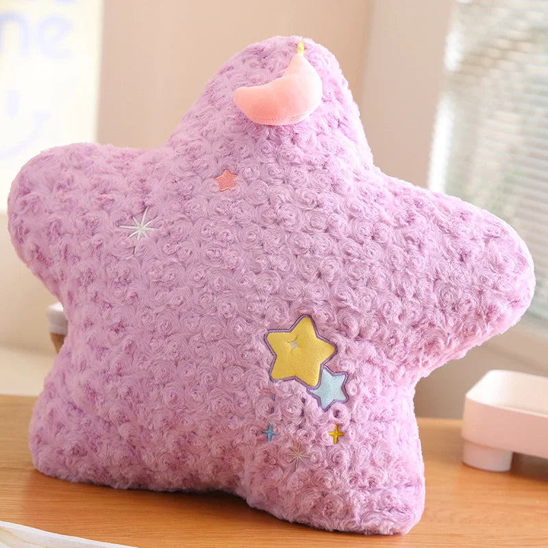 Pink star-shaped kawaii plush toy with decorative patches on a wooden surface