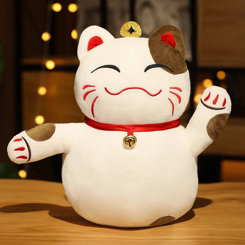 White kawaii plush cat toy with brown accents and a red collar on a wooden surface.
