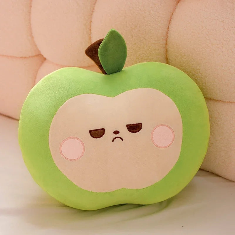Green apple-shaped kawaii pillow with a sad face on a soft pink background