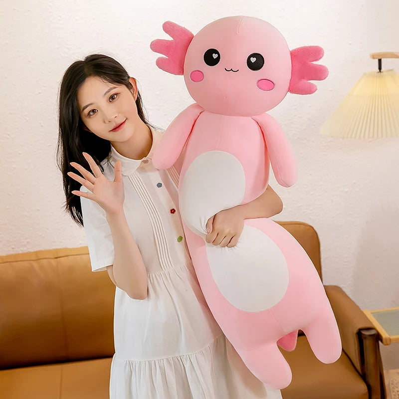 Person holding a large pink axolotl kawaii plush toy in a living room setting.