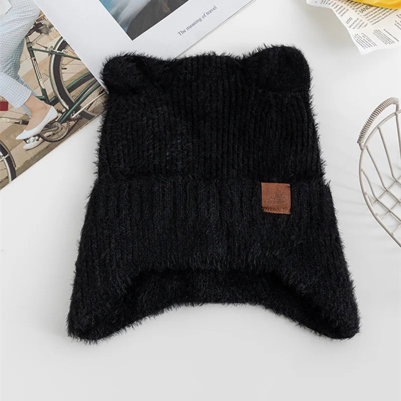 Black knitted Kawaii pouch with a brown label on a white surface