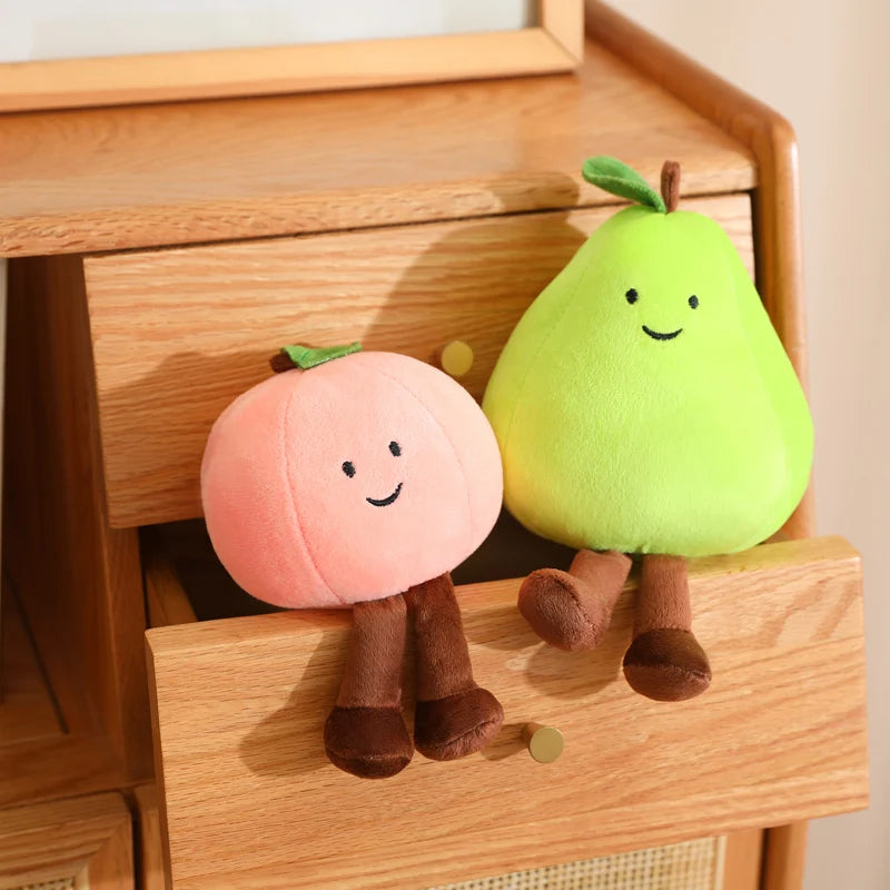 Two plush kawaii toys shaped like a peach and a pear on a wooden surface