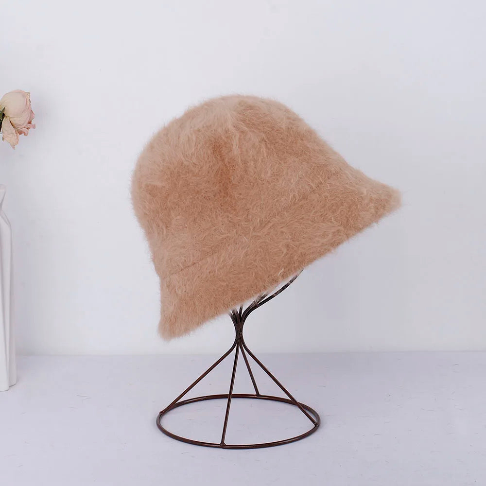 Beige fluffy Kawaii hat on a black metal stand against a white background