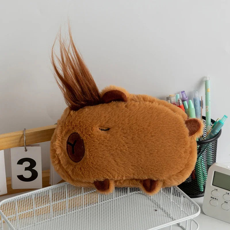 Brown kawaii plush toy resembling a horse on a desk with stationery items.