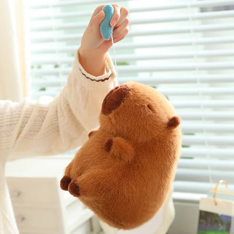 Kawaii plush toy resembling a beaver held by a person against a blurred indoor background