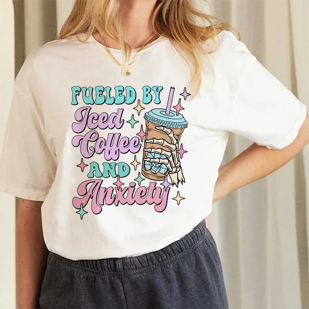 Person wearing a white t-shirt with colorful text and graphic kawaii design.
