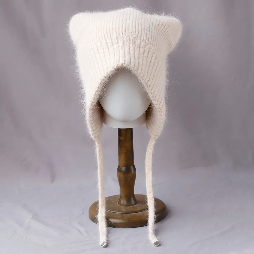 Knitted cream Kawaii hat with long earflaps on a mannequin head against a plain background