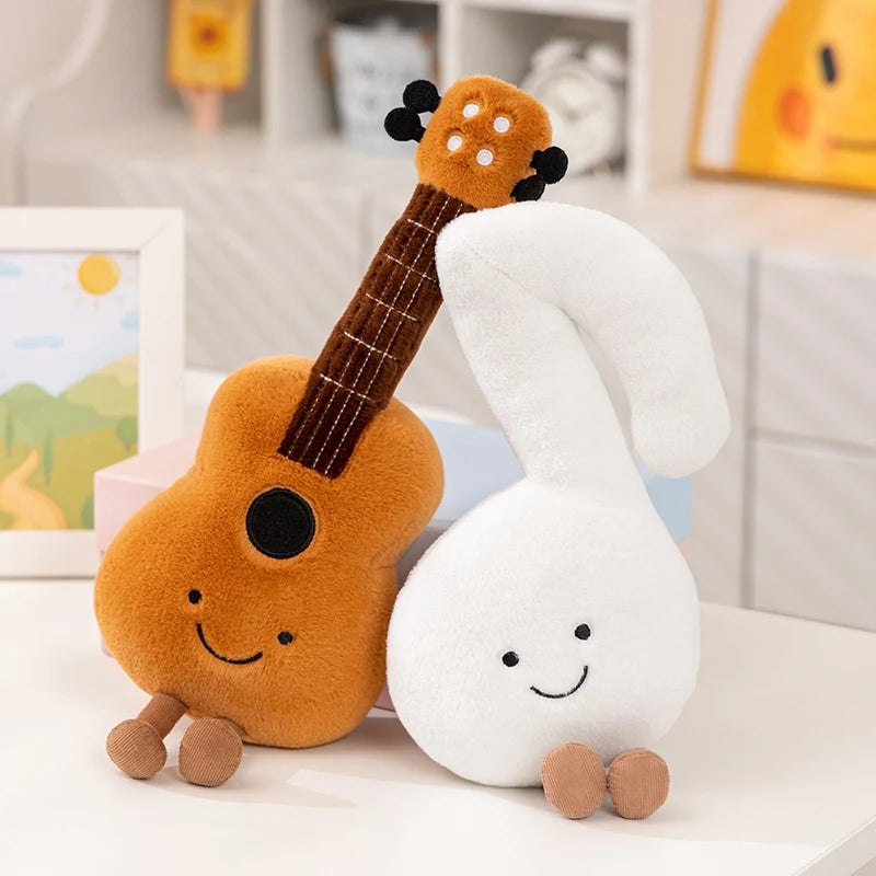 Plush kawaii toy guitar and cloud with smiling faces on a white surface.