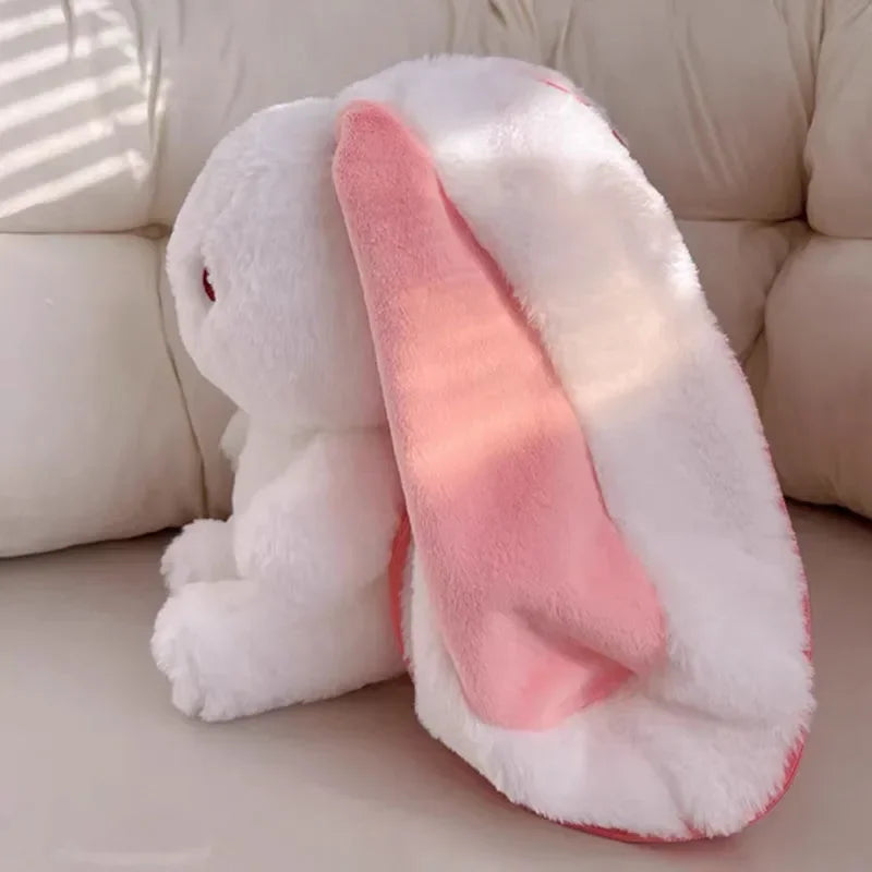 White kawaii plush bunny with pink ears on a beige couch