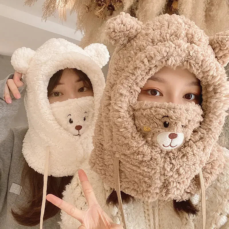 Two people wearing fluffy Kawaii bear-themed hats with face designs.