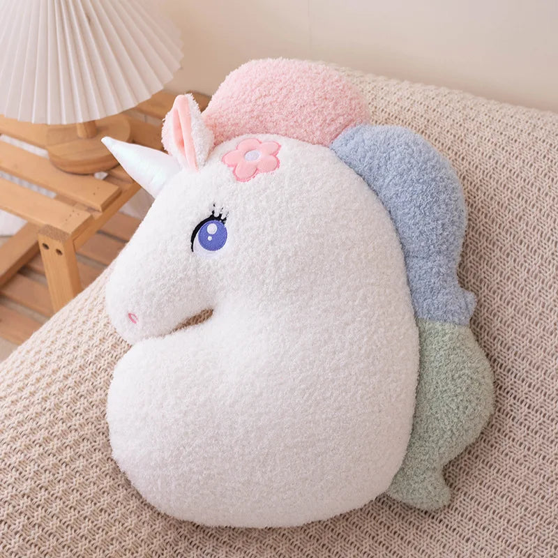 Kawaii plush toy unicorn with multicolored mane on a beige surface