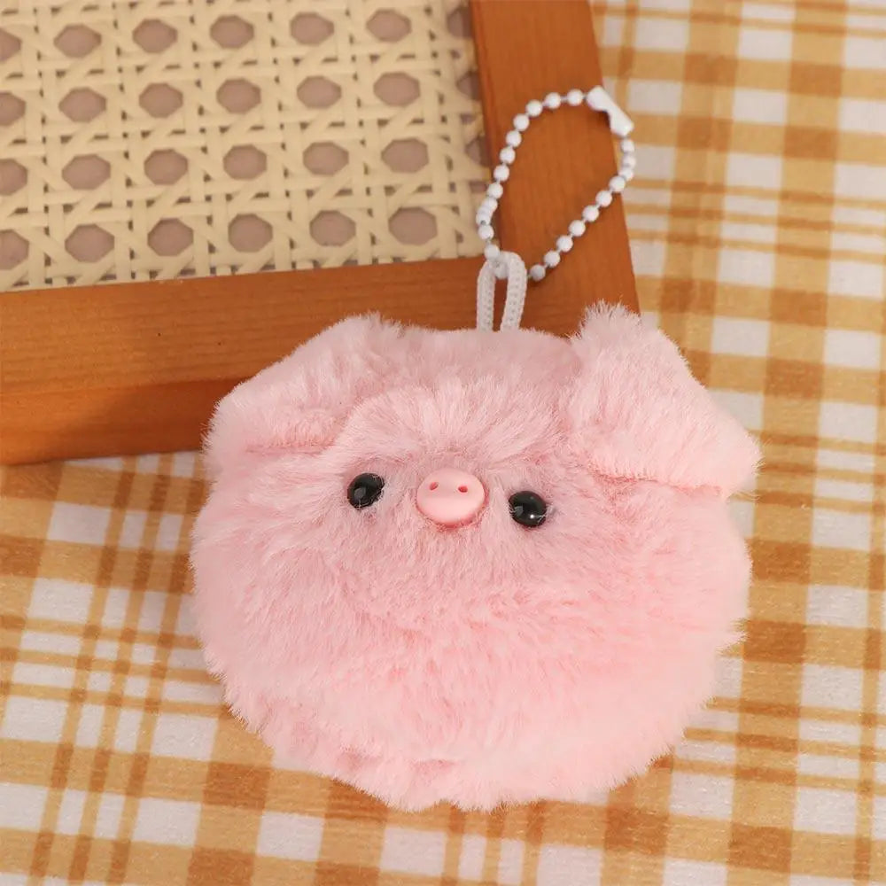 Pink fluffy kawaii keychain on a checkered fabric background