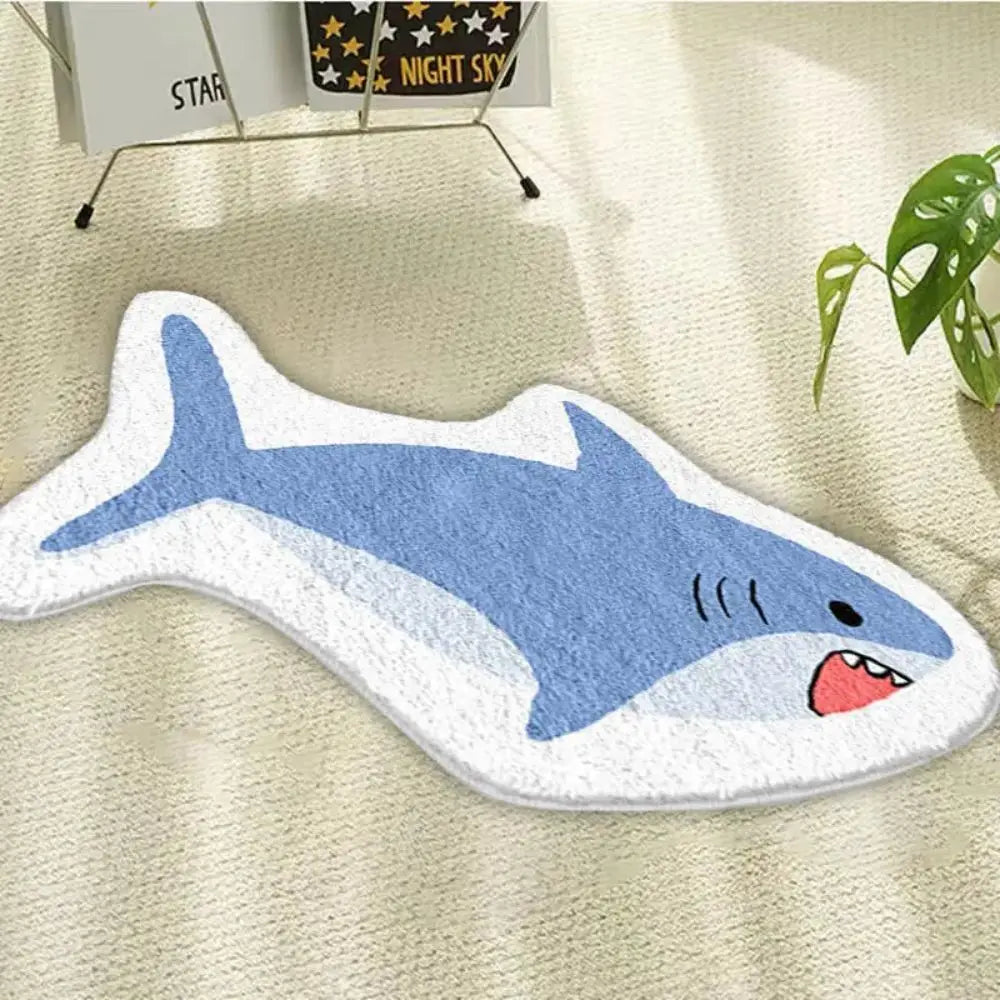 Shark-shaped kawaii bath mat on a beige carpet with a plant in the corner.