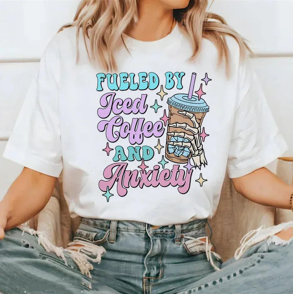 Person wearing a white t-shirt with colorful text and graphic kawaii design.