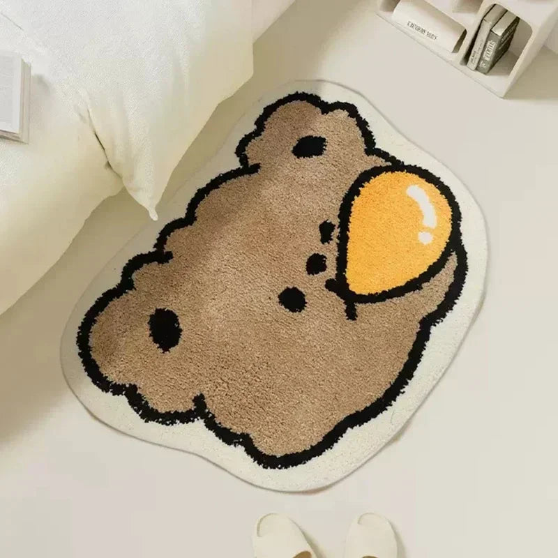 Cute Kawaii bear-shaped rug with a yellow ball on a light-colored floor.