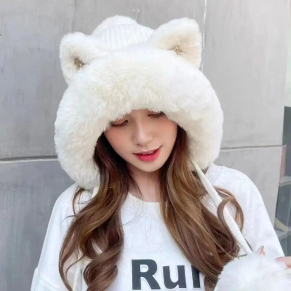 Person wearing a white fluffy Kawaii hat with cat ears against a gray background