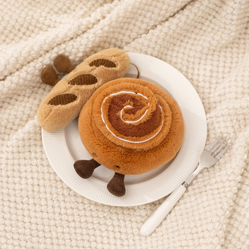 Kawaii plush cinnamon roll toy on a white plate with a fork on a textured beige surface