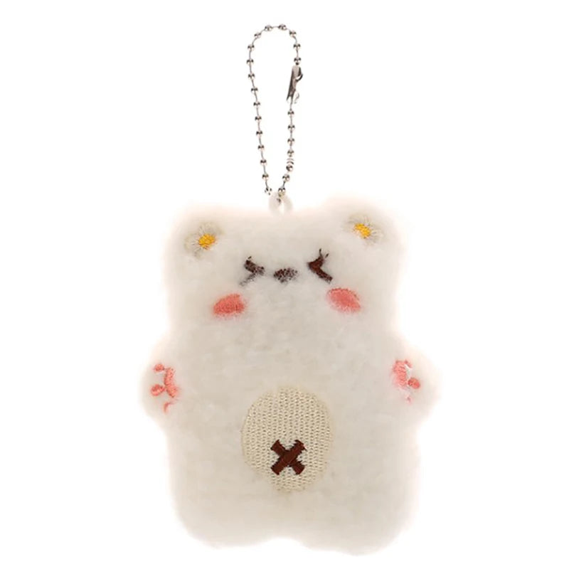 Fluffy white keychain with a kawaii face design on a white background