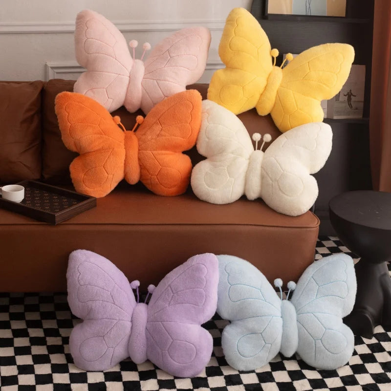 Butterfly-shaped kawaii cushions in various colors on a checkered floor.