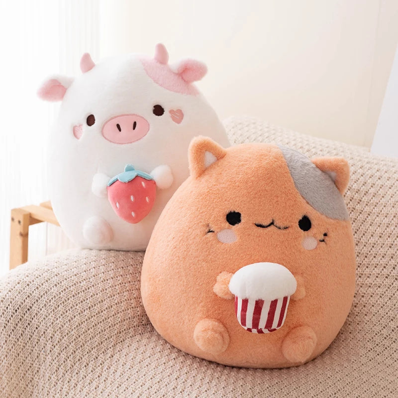 Two cute kawaii  plush toys, one resembling a pig with a strawberry and the other resembling a cat with popcorn, on a soft surface.