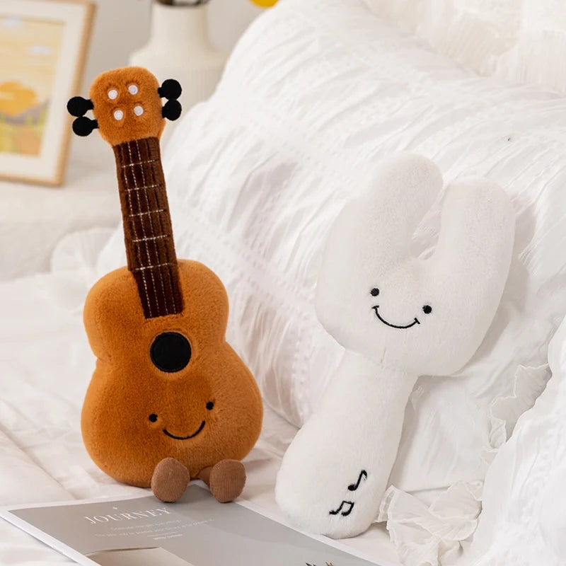 Plush kawaii toy guitar and plush cloud with smiley face on a white surface